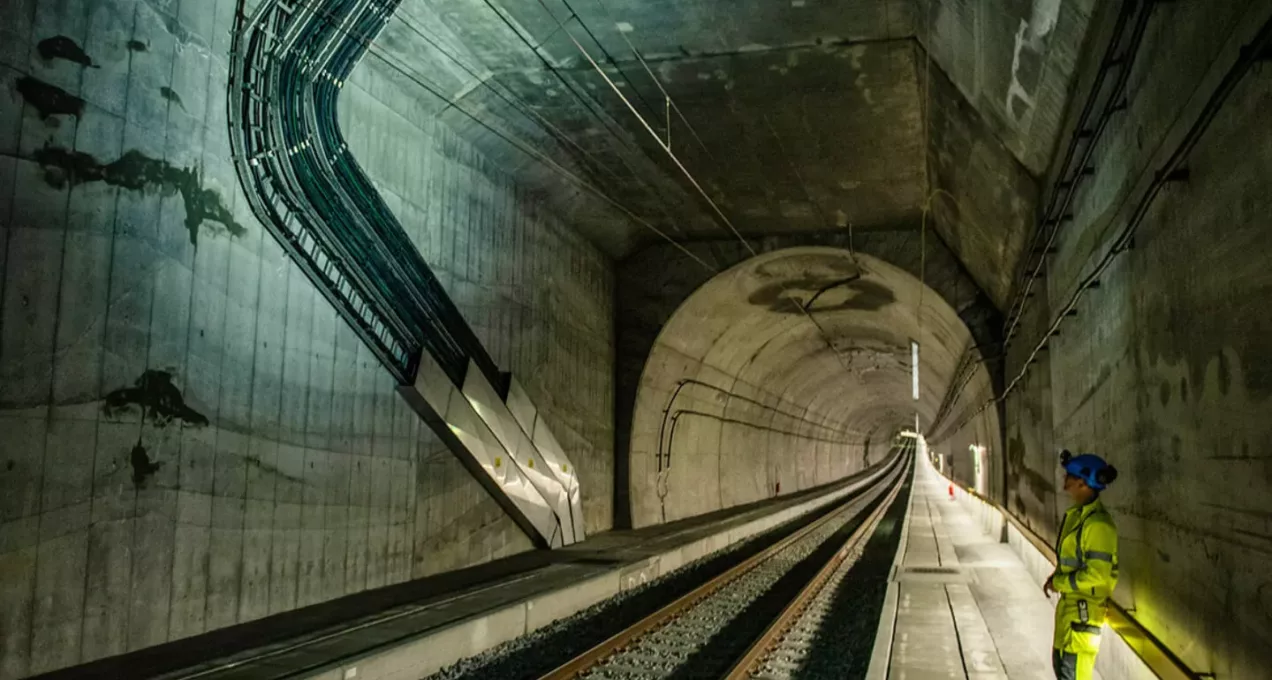 Train tunnel with one worker inspecting the electrics.